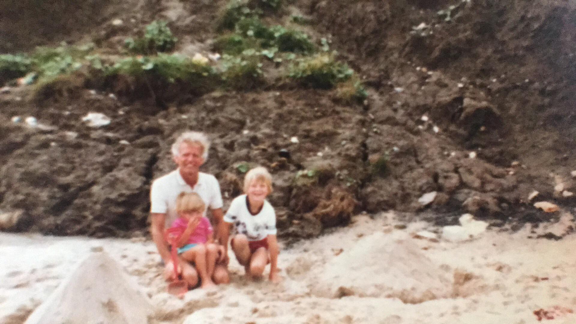 Photo of my Grandad with my and my sister, on a beach, possibly mid-80s